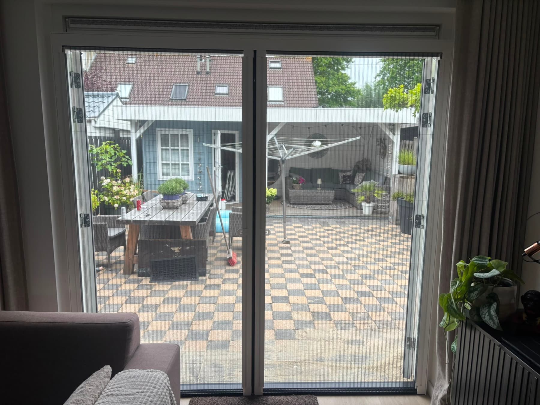 Plisséhordeur voor openslaande tuindeuren, zicht op de tuin