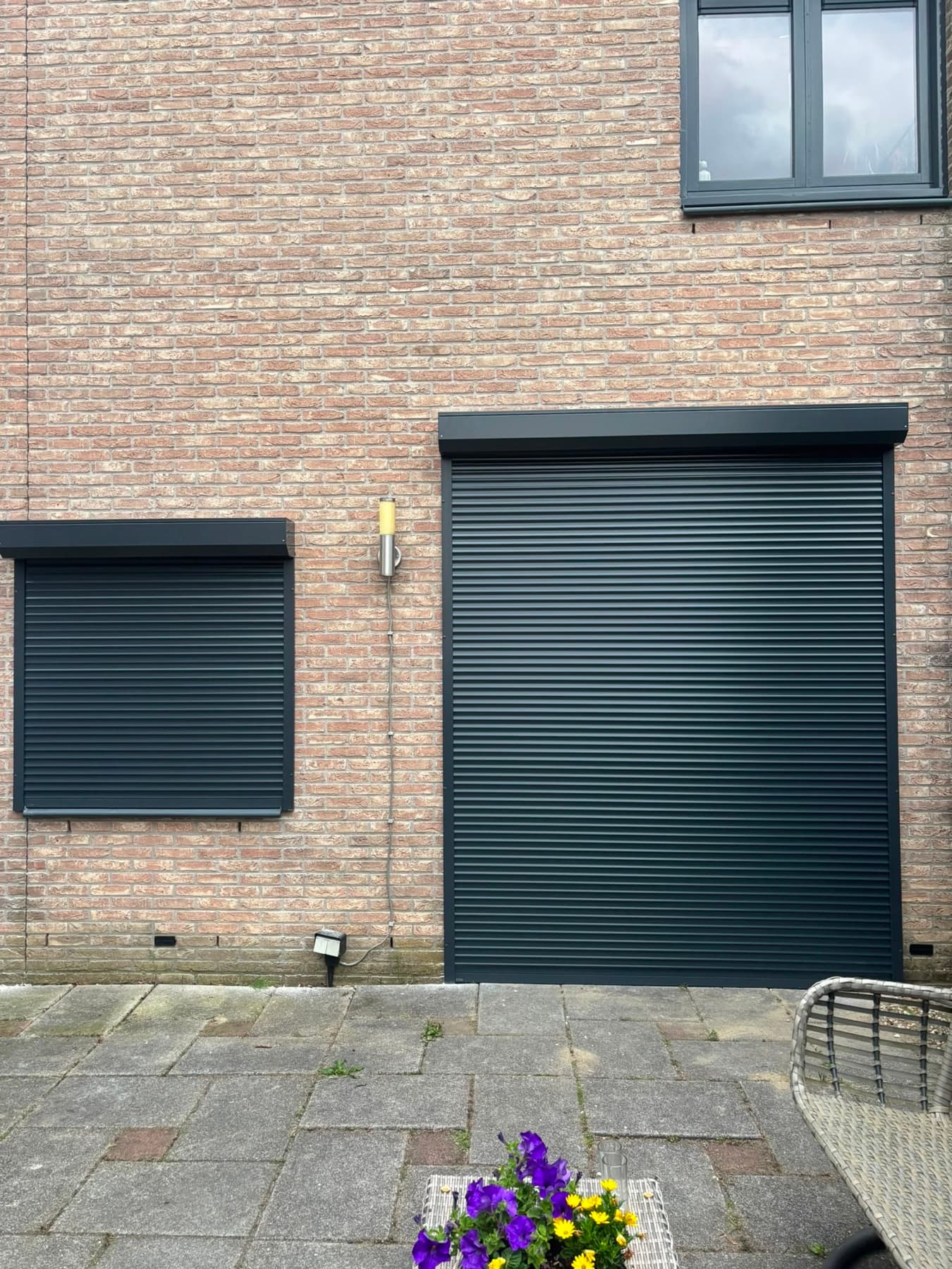 Antracietgrijs rolluik op maat voor een grote pui, met kleiner rolluik ernaast
